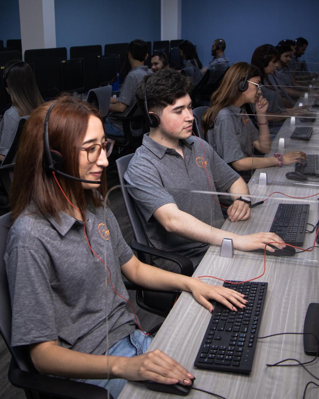 Bilingual agents with headsets working on the MM Online production floor